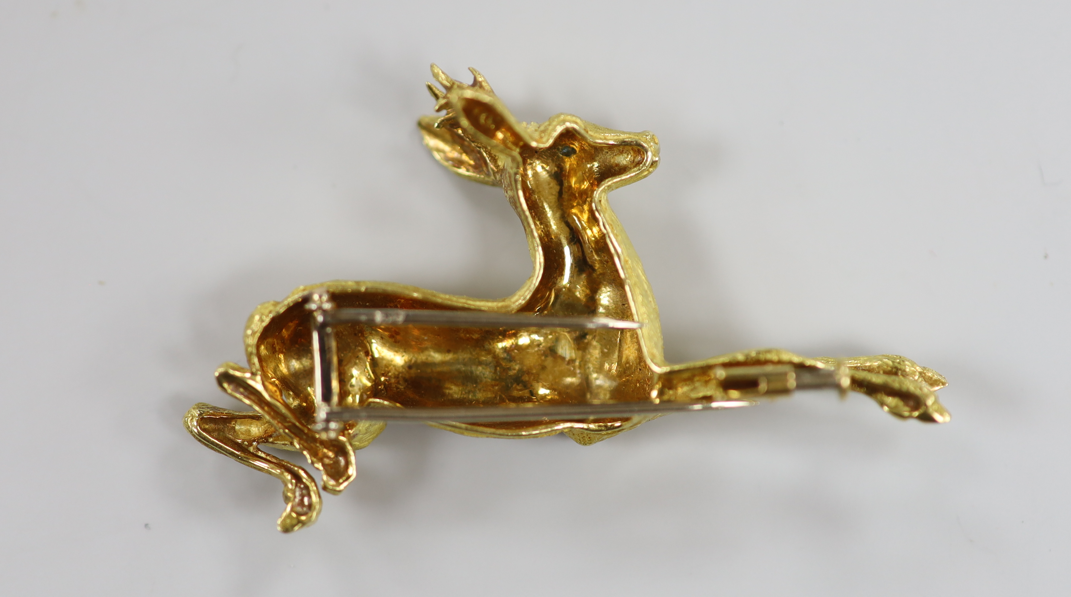 A continental textured yellow metal and gem set novelty clip brooch, modelled as a leaping deer, 55mm, 17.5 grams.